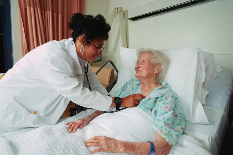Elderly woman getting a checkup from a doctor holding a stethoscope